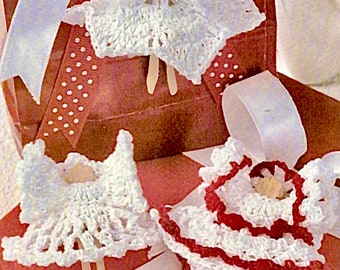 May include: Three crocheted angel ornaments with wooden dowel sticks for hanging. The angels are dressed in white and red crochet dresses with ruffled edges.