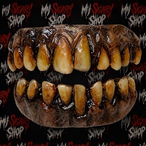 May include: A set of prosthetic teeth featuring a dark, decayed gum line and stained, yellowed, uneven teeth. The upper and lower dental arches are connected, displaying a weathered, textured appearance with realistic shading and glossy finish.