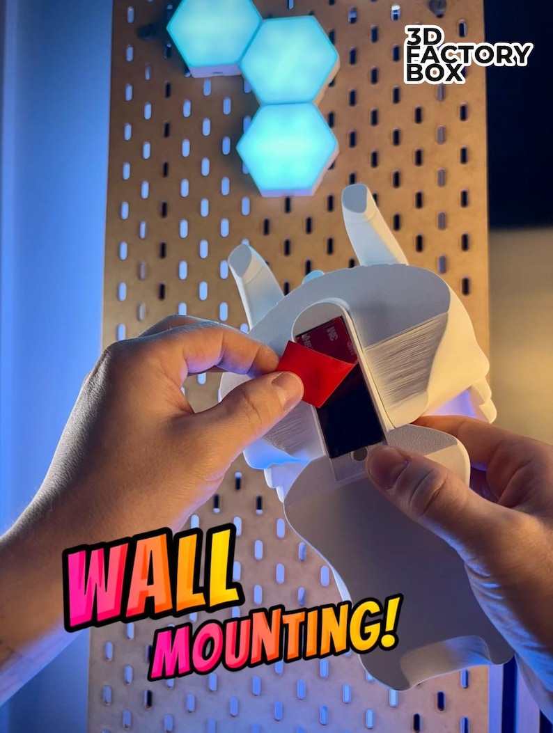 May include: A white 3D-printed wall mount is being prepared for installation. The mount is designed to hold hexagonal LED lights. The image includes the text "WALL MOUNTING!" and the logo for "3D FACTORY BOX".