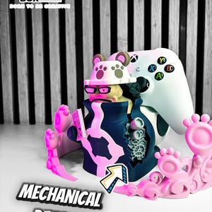 Puede incluir: Figura impresa en 3D con sombrero de oso, gafas y abrigo azul marino, sosteniendo un libro. La figura es rosa y azul, con un mando de Xbox blanco en el fondo. El texto "MECHANICAL DETAILS" es visible.