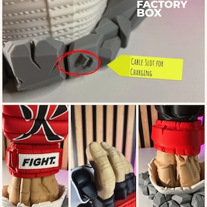 Puede incluir: Un soporte para mando impreso en 3D con un pu&ntilde;o estilizado que lleva un guante rojo con el texto FIGHT y un car&aacute;cter japon&eacute;s. La base tiene forma de rocas grises e incluye una ranura para el cable de carga del mando.