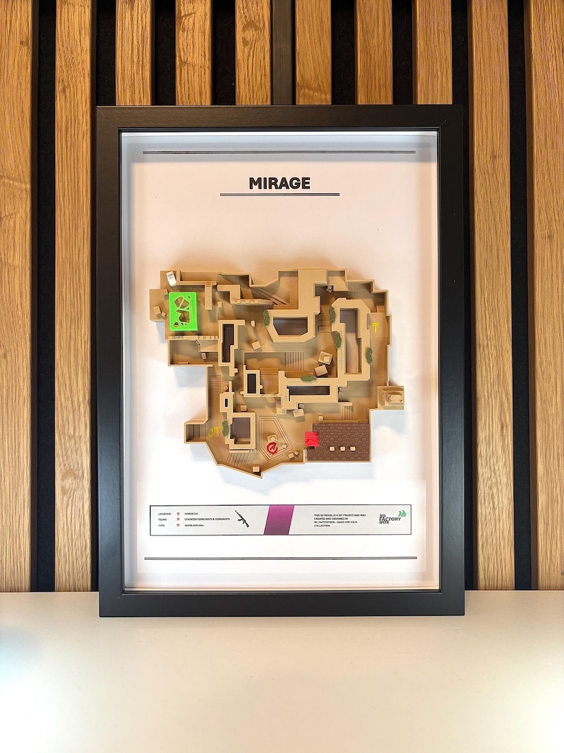 May include: A framed map of the Mirage map from the video game Counter-Strike: Global Offensive. The map is printed on a beige background with brown and green accents. The frame is black and the title "MIRAGE" is printed in black at the top of the map.