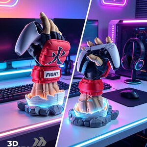 Puede incluir: Un soporte para mando de juego con forma de mano que lleva un guante de artes marciales rojo y negro con el texto FIGHT y un car&aacute;cter japon&eacute;s. La base presenta un dise&ntilde;o de piedra agrietada con luz azul, sosteniendo un mando blanco y negro.