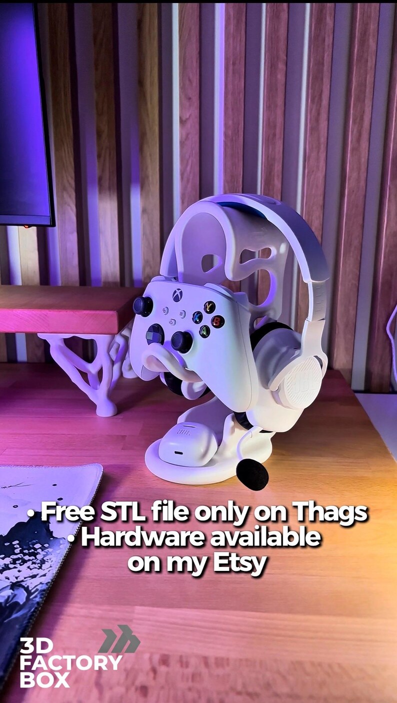 Peut inclure: Support blanc pour casque et manette de jeu. Le support maintient une manette Xbox blanche et un casque blanc et gris. Le support est sur une surface en bois. Le texte sur l'image dit "Free STL file only on Thags Hardware available on my Etsy".