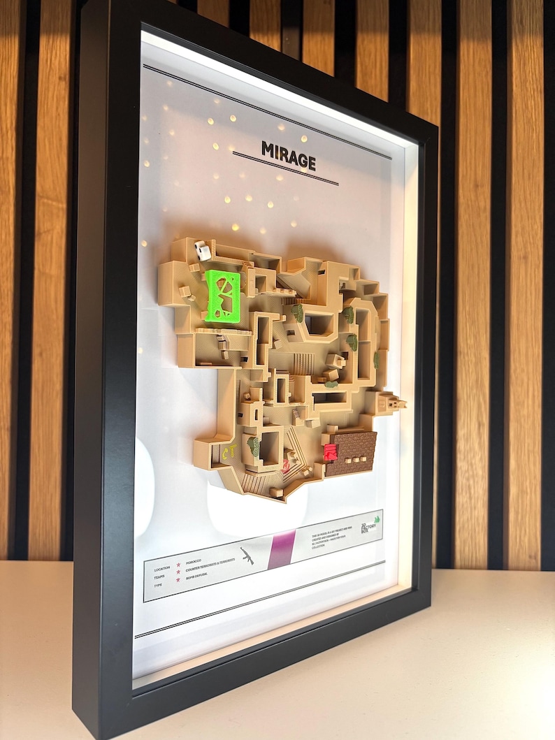 May include: A framed 3D map of the Mirage map from the video game Counter-Strike: Global Offensive. The map is made of beige plastic and features the text "MIRAGE" at the top.