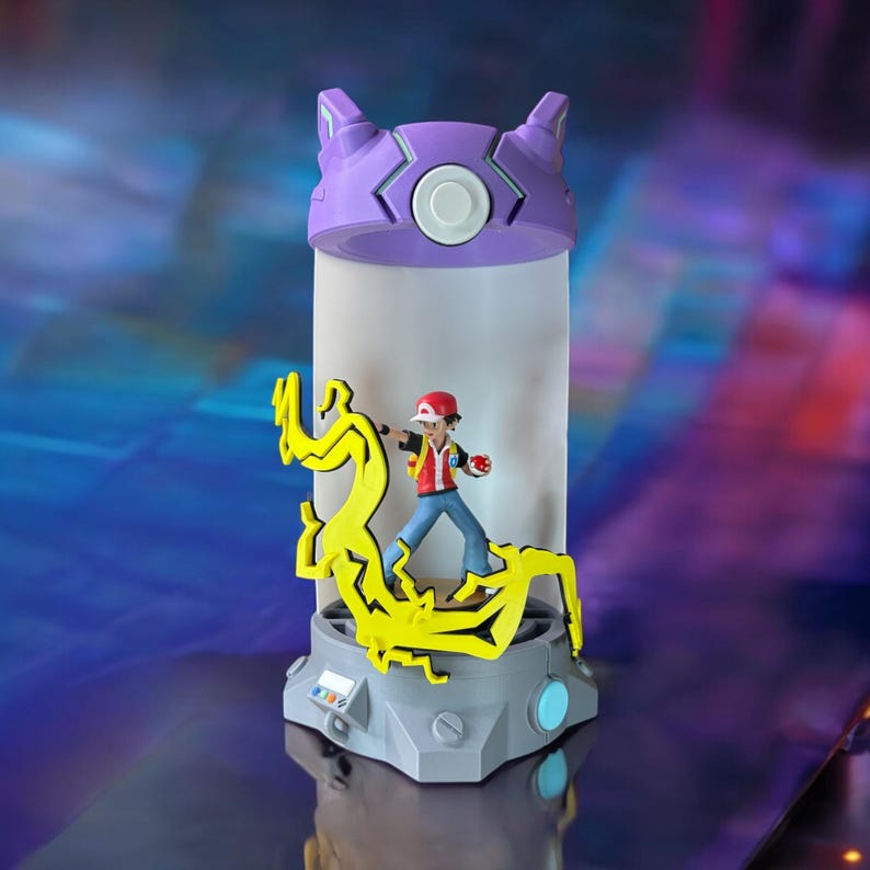 May include: A purple and gray Pokemon Poke Ball lamp with a yellow lightning bolt design and a figure of a Pokemon trainer inside.
