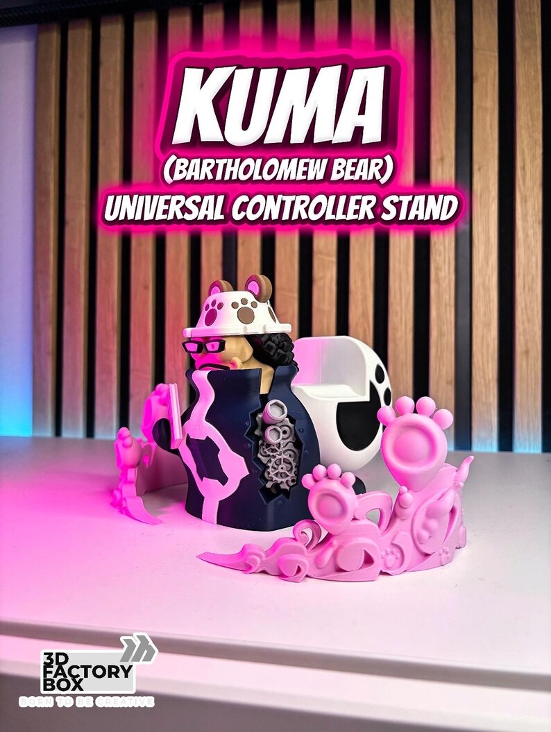 Puede incluir: Un soporte universal para controlador Kuma (Bartholomew Bear) rosa y negro. El soporte presenta un dise&ntilde;o detallado con el texto "KUMA" y "UNIVERSAL CONTROLLER STAND" en un brillo rosa ne&oacute;n.