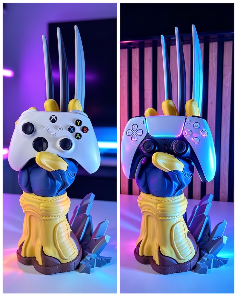 May include: A blue and yellow glove-shaped controller stand featuring three long silver claws extending upward. The base is sculpted with jagged rock-like details. The stand is shown holding a white Xbox controller and a white PlayStation controller.
