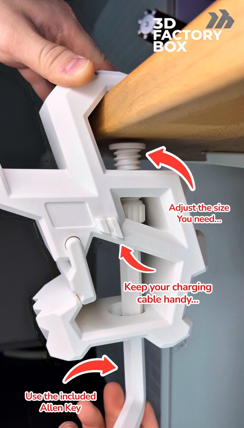 May include: White 3D Factory Box desk clamp with adjustable size and cable management. The clamp is being attached to a wooden surface. Text on the image reads: "Adjust the size you need..." and "Keep your charging cable handy..."