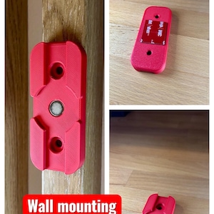 May include: Red wall mounting bracket with a magnetic center and two screw holes. The bracket is shown in multiple views, including one attached to a wooden surface. Text on the image reads "Wall mounting included!"