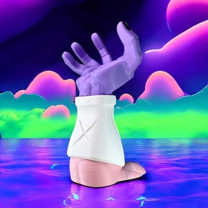 Op de afbeelding: Een surrealistische sculptuur van een hand die omhoog reikt. De hand is lichtpaars met zwarte vingernagels. De pols is omhuld door een witte mouw met een 'X'-ontwerp. De basis is lichtroze. De achtergrond toont een kleurrijk, dromerig landschap.