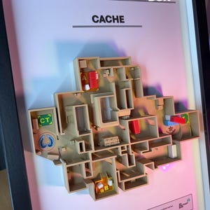 May include: A framed 3D model of a map labeled "CACHE". The model is beige with red and blue accents, depicting a complex layout with various rooms and pathways. The frame includes the text "3D FACTORY BOX".