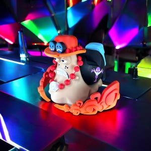 Peut inclure: Une figurine de style cartoon color&eacute;e avec un chapeau rouge, un collier rouge et blanc et un motif bleu et violet. La figurine est en plastique et a un aspect fantaisiste et cartoon.