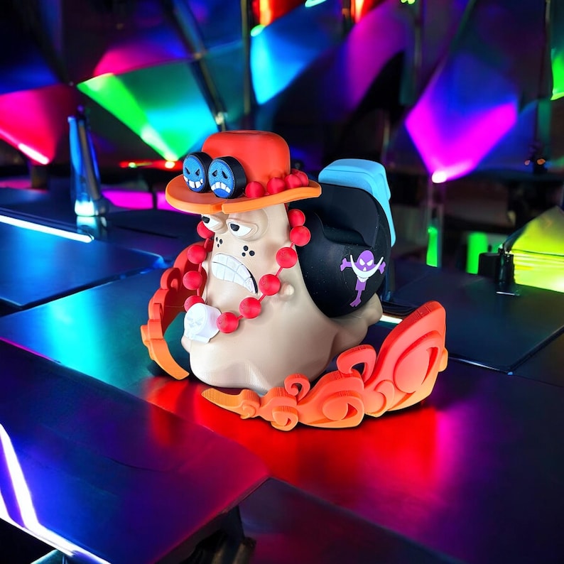 Peut inclure: Une figurine de style cartoon color&eacute;e avec un chapeau rouge, un collier rouge et blanc et un motif bleu et violet. La figurine est en plastique et a un aspect fantaisiste et cartoon.