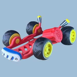 K&ouml;nnte beinhalten: Ein rotes und schwarzes Spielzeugauto mit gelben Akzenten. Das Auto hat vier schwarze R&auml;der mit gelben Felgen, ein rotes Fahrgestell und einen roten Tankdeckel. Die Vorderseite hat ein blaues, wei&szlig;es und rotes Design.