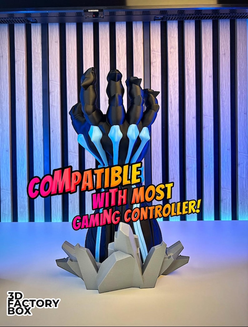 May include: A black and blue gaming controller stand shaped like a hand, with the text "COMPATIBLE WITH MOST GAMING CONTROLLER!" in pink and yellow. The stand has a gray base with the text "3D FACTORY BOX".