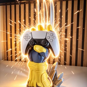 May include: A yellow and blue gloved hand sculpture holding a white and black game controller. Three metallic blades extend upward from the hand, surrounded by bright light and sparks. The base features jagged gray rock-like elements.