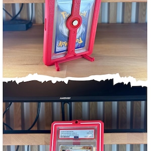 May include: Red 3D Factory Box card holder with a graded Pok&eacute;mon card inside. The card features a red Groudon ex character. The holder has the text "3D FACTORY BOX" and "AMZFAST".