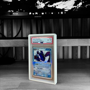 May include: A graded Pok&eacute;mon card featuring Kyogre ex from the 2006 Black Star Promos set. The card is encased in a clear protective holder with a white frame. The card's artwork showcases a blue and white Kyogre with the text "Kyogre ex".