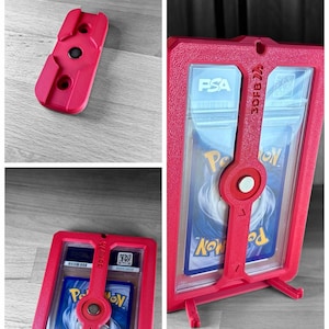 May include: A red 3D-printed card holder with a clear plastic insert, designed to hold a graded trading card. The holder features a locking mechanism and a stand for display. The text "3DFB" is visible.