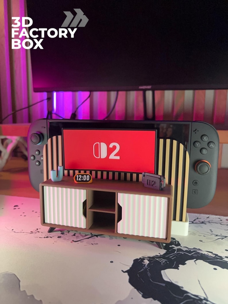 May include: A 3D-printed miniature entertainment center with a Nintendo Switch console. The center features a brown cabinet with pink and white striped doors, a small clock, and a miniature game cartridge. The Switch screen displays the number "2".