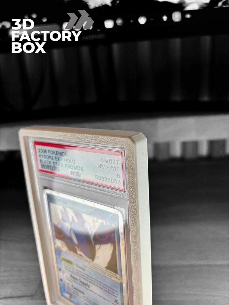 May include: A graded Pok&eacute;mon card in a protective case. The card features Kyogre EX-Hold from the 2006 Black Star Promos set. The case is labeled with the grade NM-MT 8 and the number 58886958. The text "3D FACTORY BOX" is visible in the upper left corner.