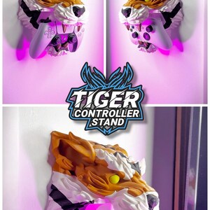 May include: A tiger-head controller stand in shades of brown, white, and orange, designed to hold a gaming controller. The stand has yellow eyes and sharp teeth. Text on the stand reads "TIGER CONTROLLER STAND". The image also includes the text "COMPATIBLE WITH THE MOST COMMON GAMING CONTROLLERS".