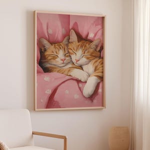 Op de afbeelding: Twee oranje tabby-katten knuffelen en slapen in een roze deken met witte stippen.