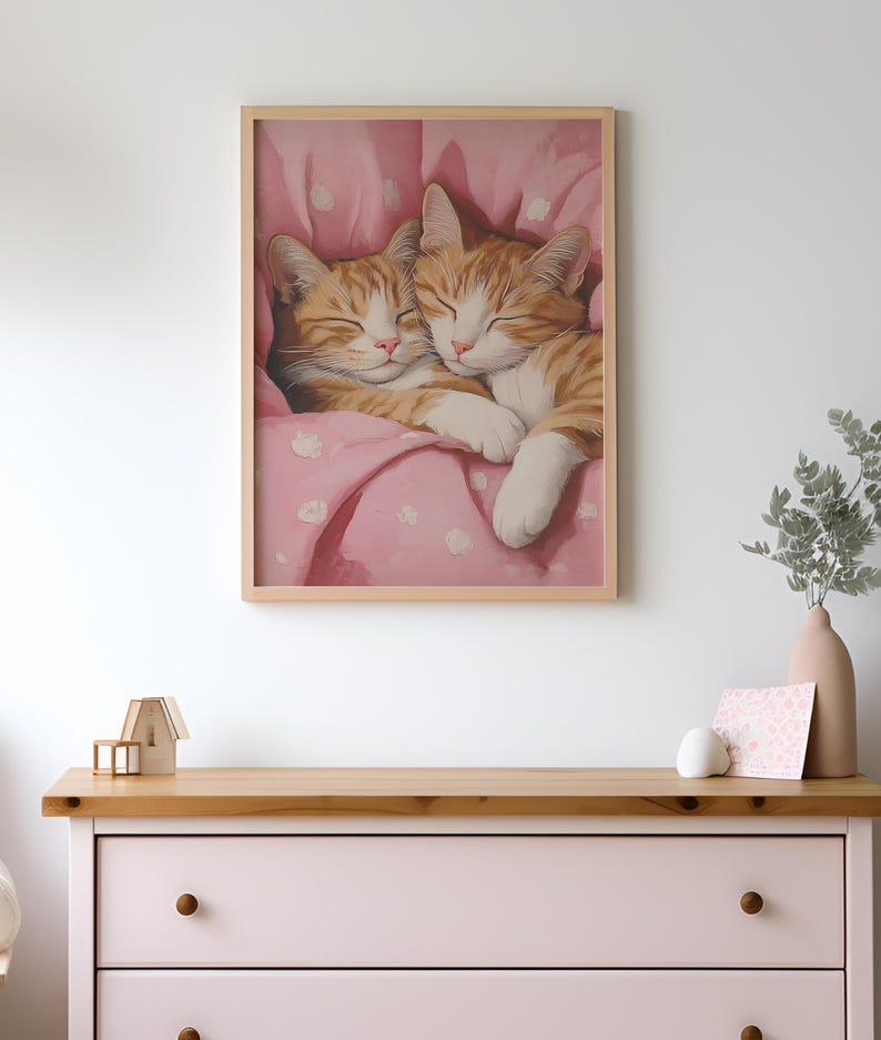 Op de afbeelding: Twee oranje tabby-katten knuffelen en slapen in een roze deken met witte stippen.