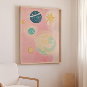 May include: A framed painting of a pink sky with blue, green, and yellow planets and stars. The planets have a watercolor effect.