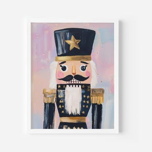 May include: A framed painting of a nutcracker soldier. The nutcracker has a black hat with a gold star, a black mustache, and a white beard. The soldier's uniform is black with gold accents and stars. The background is a blend of pink and blue.