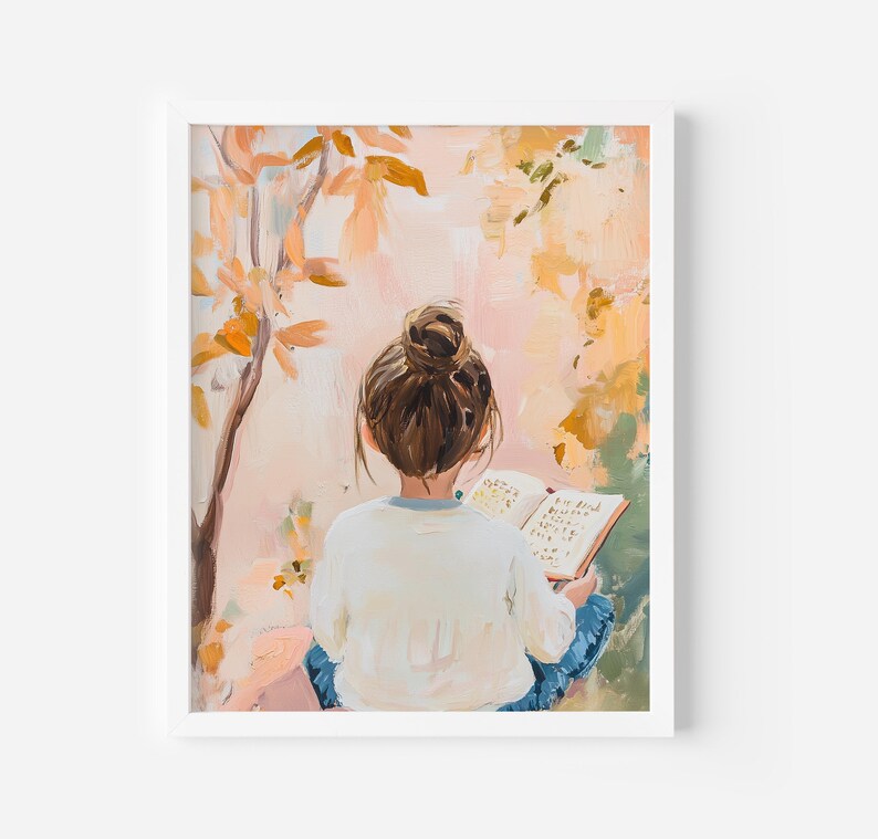 May include: An art print depicting a person with brown hair in a bun, wearing a white top and blue jeans, reading a book. The background has a tree with orange leaves and a soft, colourful, impressionistic style.