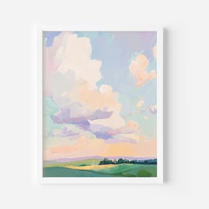 Puede incluir: Pintura de paisaje enmarcada que representa un cielo pastel con nubes esponjosas en tonos melocotón, lavanda y azul. El primer plano muestra colinas verdes y una línea de árboles, creando una escena tranquila. La obra está enmarcada en blanco.