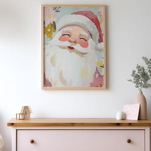 May include: A framed painting of Santa Claus with a white beard and closed eyes. He is surrounded by colorful flowers and a light blue background.