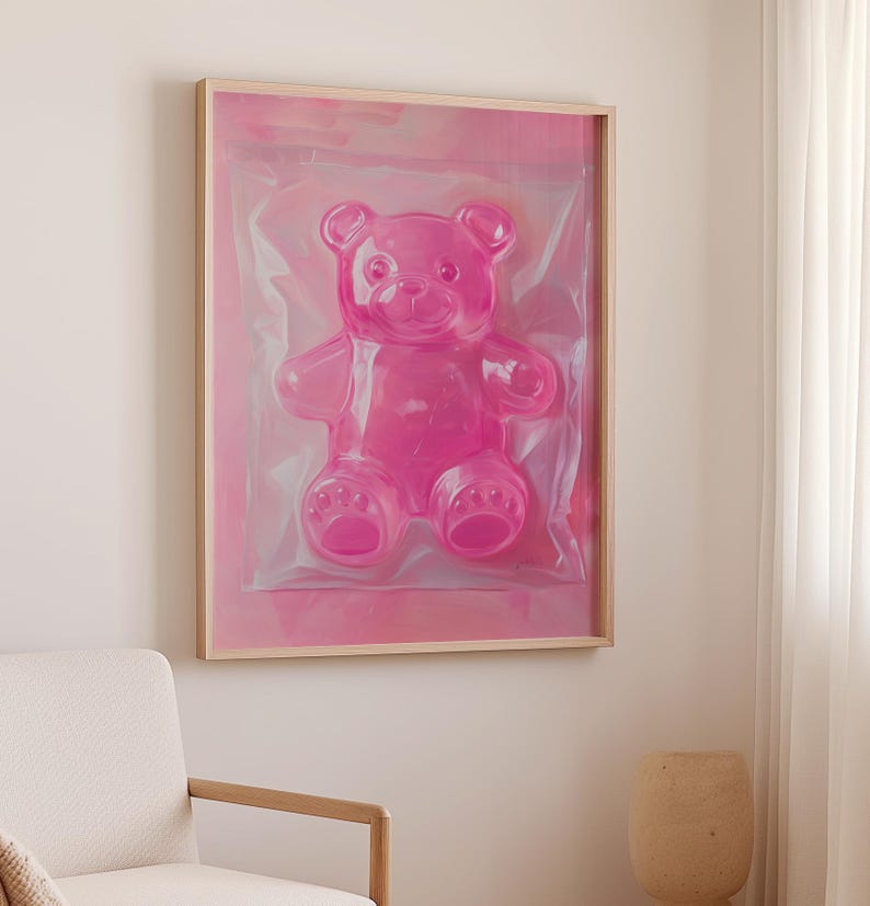 May include: A framed print of a pink gummy bear in a clear plastic bag. The bear is sitting up and has a friendly expression.