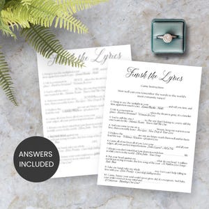 May include: A game called "Finish the Lyrics" with instructions and song lyrics printed on white paper. A round sticker with "ANSWERS INCLUDED" is visible. A diamond ring sits in a teal box, and a fern is in the background.