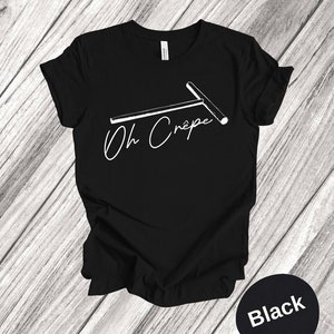 May include: Black t-shirt with a white graphic of a crepe maker and the text "Oh Crepe".