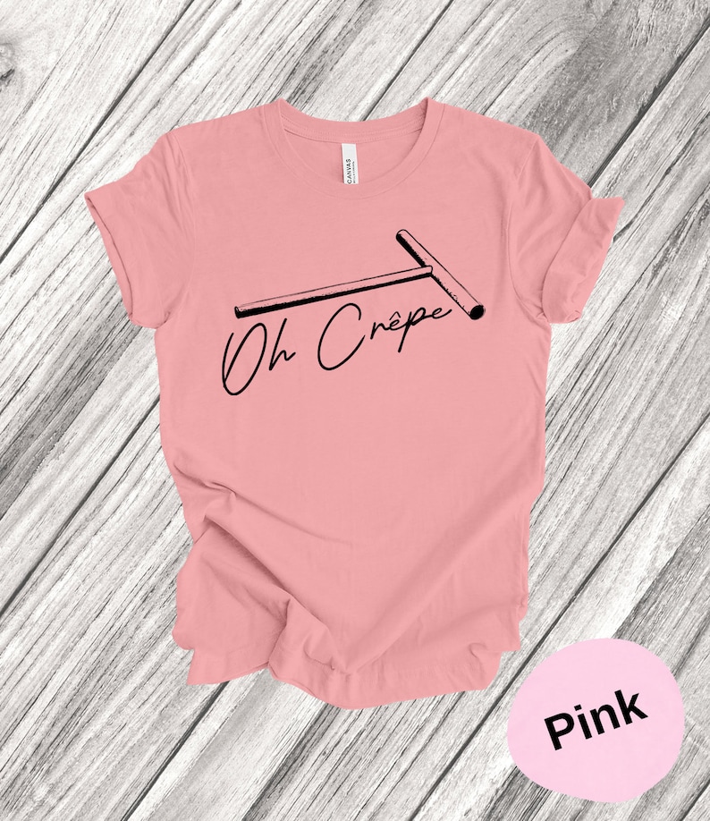 May include: Pink t-shirt with a black graphic of a crepe maker and the text "Oh Cr&ecirc;pe".
