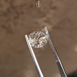 Close-up view of a sparkling oval cut lab-grown diamond resting on a white marble surface, illuminated by soft studio lighting. The clarity and polish reveal expert craftsmanship, while its symmetry radiates a luxurious charm. Sustainably created and conflict-free, this oval diamond is perfect for eco-conscious jewelry lovers. A modern choice for engagement rings, its elongated shape and exceptional brilliance bring sophistication, sustainability
