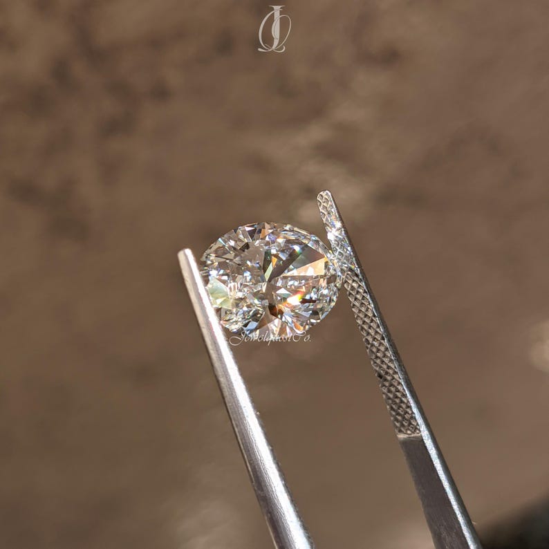 Close-up view of a sparkling oval cut lab-grown diamond resting on a white marble surface, illuminated by soft studio lighting. The clarity and polish reveal expert craftsmanship, while its symmetry radiates a luxurious charm. Sustainably created and conflict-free, this oval diamond is perfect for eco-conscious jewelry lovers. A modern choice for engagement rings, its elongated shape and exceptional brilliance bring sophistication, sustainability