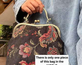 シルク製のハンドバッグ。黒と金の配色で、黒のバラの刺繍と 