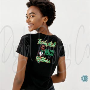 May include: Black t-shirt with green and yellow text and a graphic of a person. The text reads "Florida A&M HBCU Rattlers". The graphic is of a person wearing a green top and white pants.