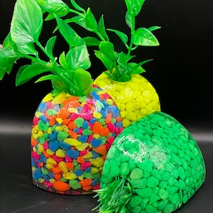 Può includere: Tre vasi in resina a forma di cuore riempiti con ciottoli colorati. I vasi sono trasparenti e mostrano i ciottoli all'interno. I vasi sono riempiti con ciottoli verdi, gialli e multicolori.