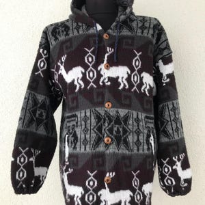 May include: A white ceramic mug with a black handle and the text "But First, Coffee" in a bold, black font. The mug is set against a blurred background, suggesting a cozy setting.