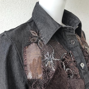 Puede incluir: Chaqueta vaquera gris oscuro con parches decorativos en tonos marrón y beige. Los parches presentan bordados intrincados y tejidos texturizados, incluyendo un material similar a una red y pana. La chaqueta tiene un cuello clásico y cierre de botones.