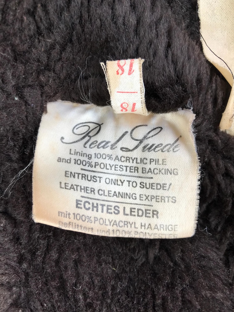 K&ouml;nnte beinhalten: Ein wei&szlig;es Etikett mit schwarzem Text, der "Real Suede" und "Entrust only to suede/leather cleaning experts" und "Echtes Leder mit 100% Polyacryl haarige gefilttert und 100% Polyester" lautet.