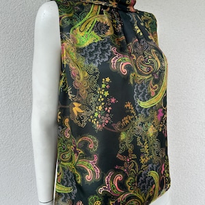 Peut inclure: Un chemisier sans manches à col montant sur fond noir avec un motif cachemire et floral multicolore aux tons vert néon, rose, jaune et orange. Le vêtement présente une finition satinée lisse et une encolure drapée élégante.