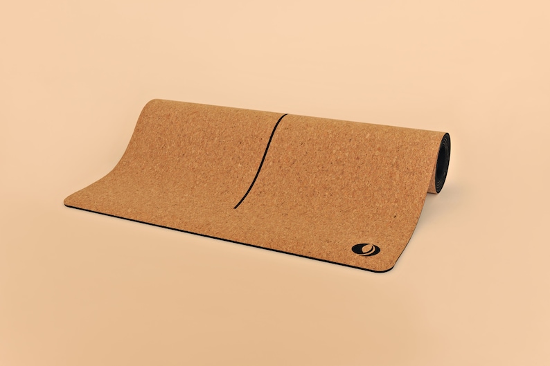 May include: A rolled up cork yoga mat with a black line down the center and a black logo on the bottom right corner.
