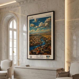 May include: A framed print of Clovis, California, from 1890, featuring an aerial view of the city with a river running through it. The print has a vintage aesthetic with a beige background and a black frame. The text "Clovis" and "California" are at the top.