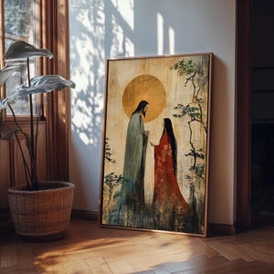May include: A framed artwork depicting two figures in long robes, set against a golden sun and a backdrop of stylized trees. The figures are in muted tones of green and red, creating a serene and spiritual ambiance. The artwork is displayed on a wooden floor.